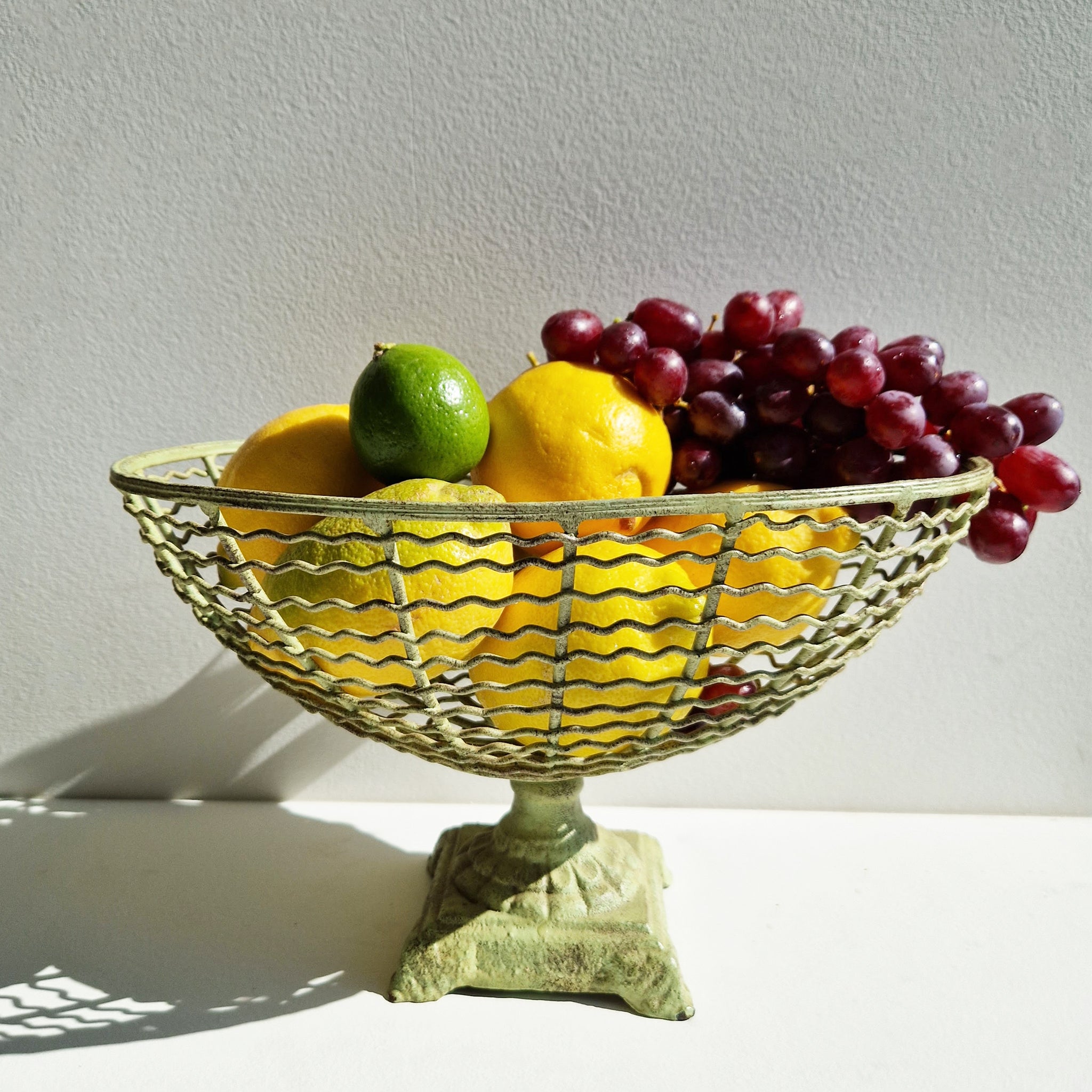 Vintage iron fruit basket on pedestal